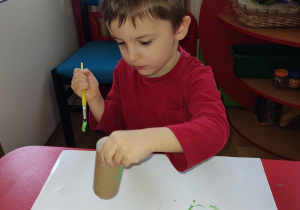 Marek maluje rolkę na zielono